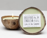 a candle in a coconut shell with the words live in the coconut