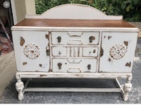 an old white buffet with a wooden top